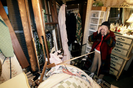 A woman cries at the site of her bedroom after a truck crashed into her house.
