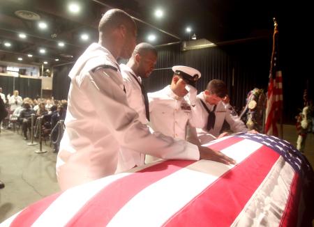 Sailors mourn over the casket of a crewmate killed when two ships collided in the Pacific Ocean.