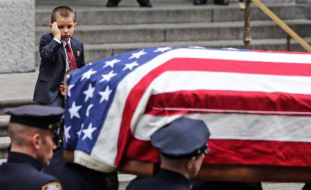 The young son of NYPD member Joseph Lemm salutes his father's casket after a funeral at St. Patricks Cathedral in New York City. Lemm, a member of the Army National Guard, was killed fighting in Afghanistan.